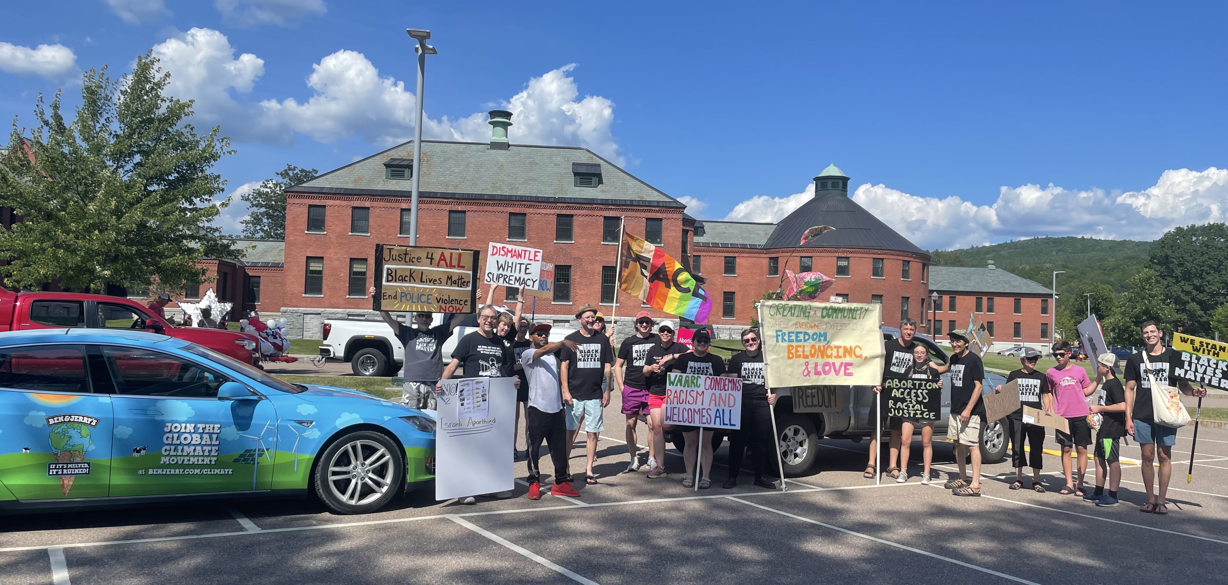 WAARC members lined up with signs, the Ben & Jerry's Tesla and their decorated truck for the NQID parade
